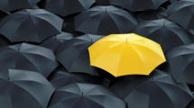Unique yellow umbrella among many dark ones. Standing out from crowd, individuality and difference concept.